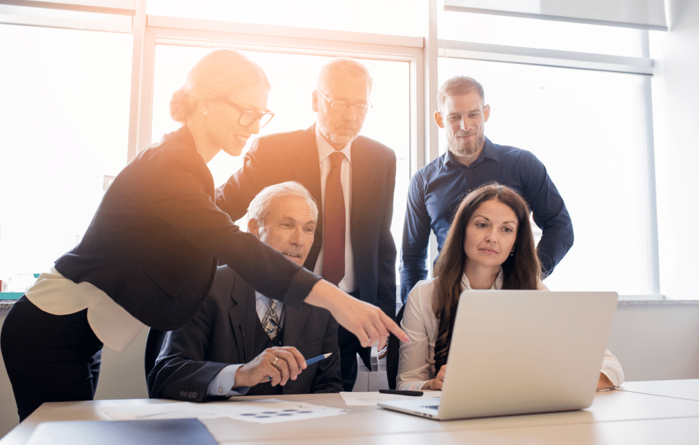 coworkers-looking-computer-talking-about-work-office